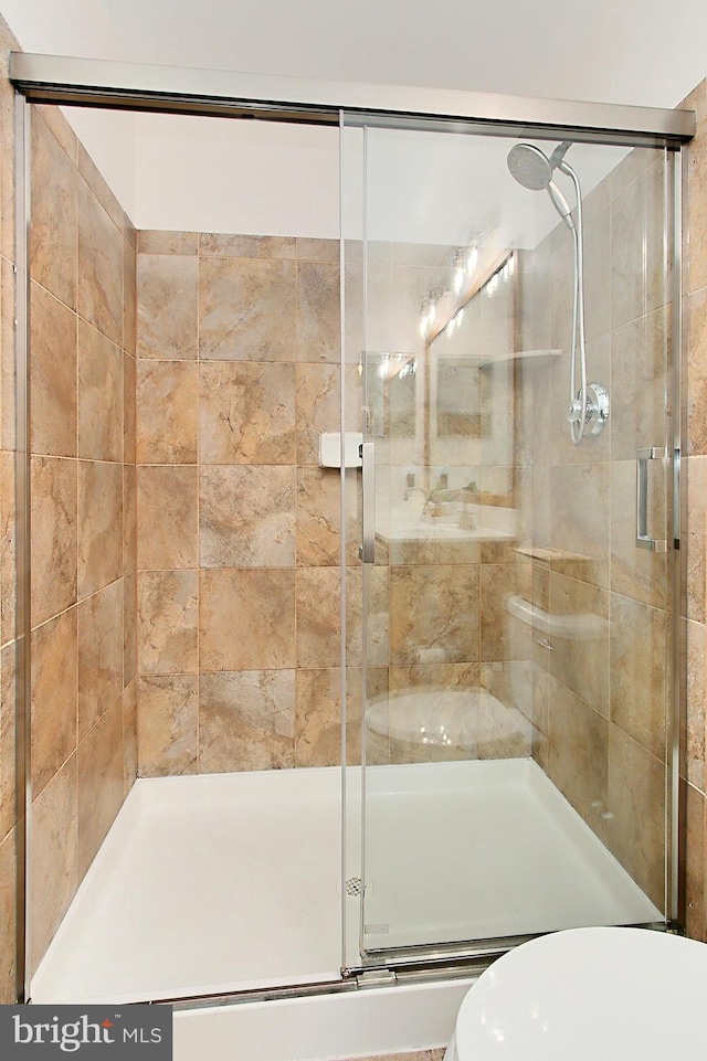 full bathroom featuring toilet and a shower stall