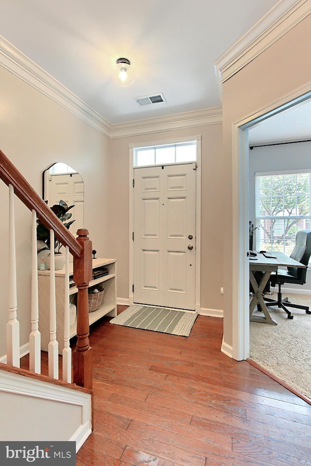 foyer entrance featuring visible vents, ornamental molding, stairs, and a healthy amount of sunlight