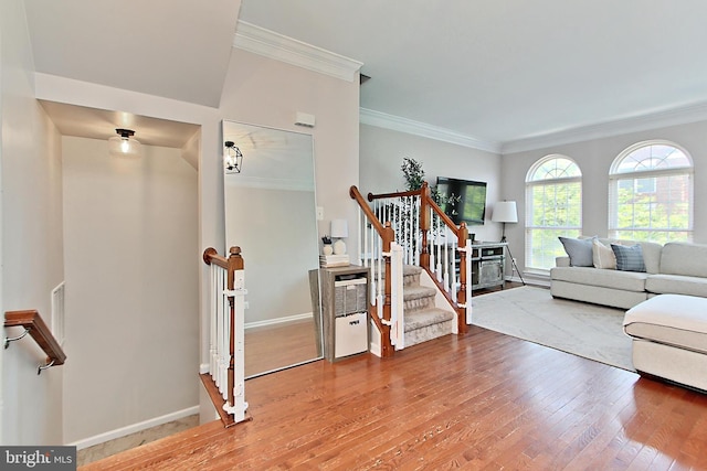 living room featuring crown molding, baseboards, stairway, and hardwood / wood-style flooring