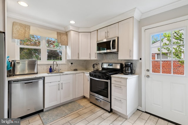 1612 Belvedere Blvd, Silver Spring, MD 20902 - kitchen featuring appliances with stainless steel finishes, a sink, ornamental molding, tasteful backsplash, and white cabinets