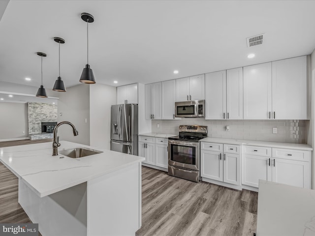 kitchen featuring visible vents, appliances with stainless steel finishes, tasteful backsplash, a sink, and white cabinetry