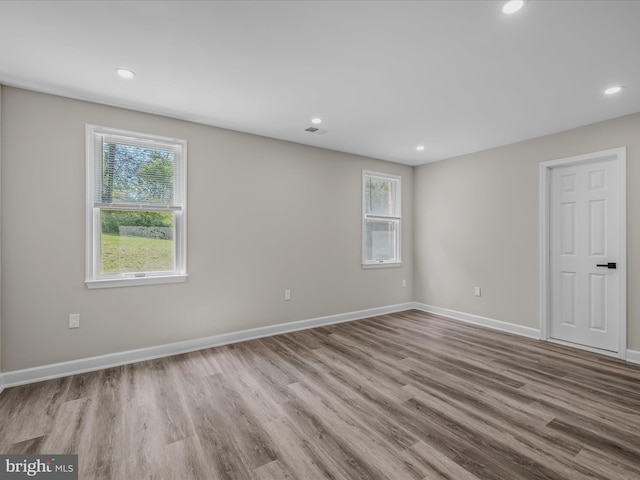 spare room featuring baseboards, recessed lighting, wood finished floors, and visible vents