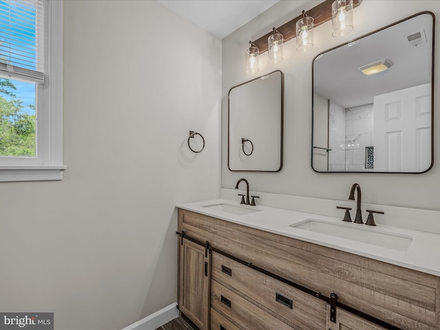 full bathroom featuring visible vents, a sink, walk in shower, and double vanity