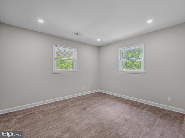 spare room featuring visible vents, recessed lighting, baseboards, and wood finished floors