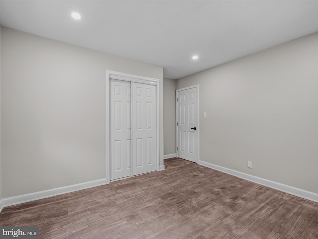 unfurnished bedroom with baseboards, a closet, and recessed lighting