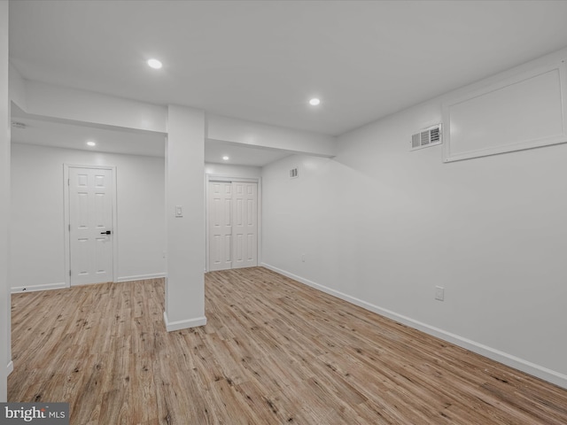 finished basement with visible vents, recessed lighting, baseboards, and wood finished floors