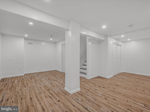 finished basement with recessed lighting, baseboards, light wood finished floors, and stairs