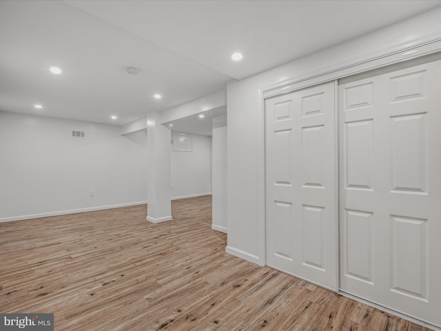 finished basement featuring recessed lighting, baseboards, light wood finished floors, and visible vents