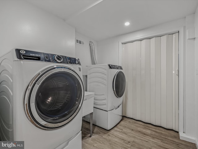 laundry room with laundry area, light wood-style flooring, recessed lighting, visible vents, and washing machine and dryer