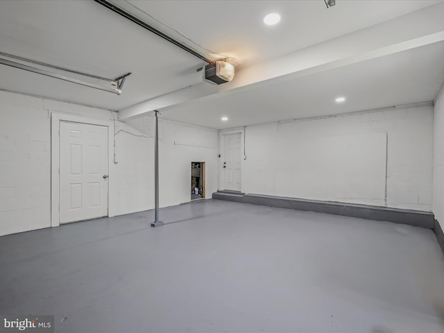 garage featuring concrete block wall, recessed lighting, and a garage door opener