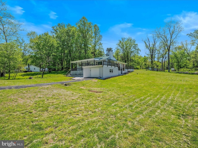 view of yard with an attached garage and aphalt driveway