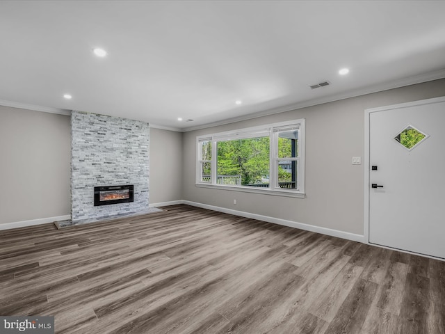 unfurnished living room featuring visible vents, crown molding, wood finished floors, a fireplace, and recessed lighting