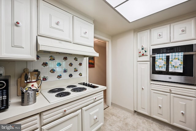 kitchen featuring white electric cooktop, under cabinet range hood, white cabinets, and oven