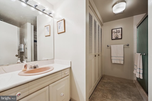 full bathroom with a closet, a shower with door, baseboards, and vanity