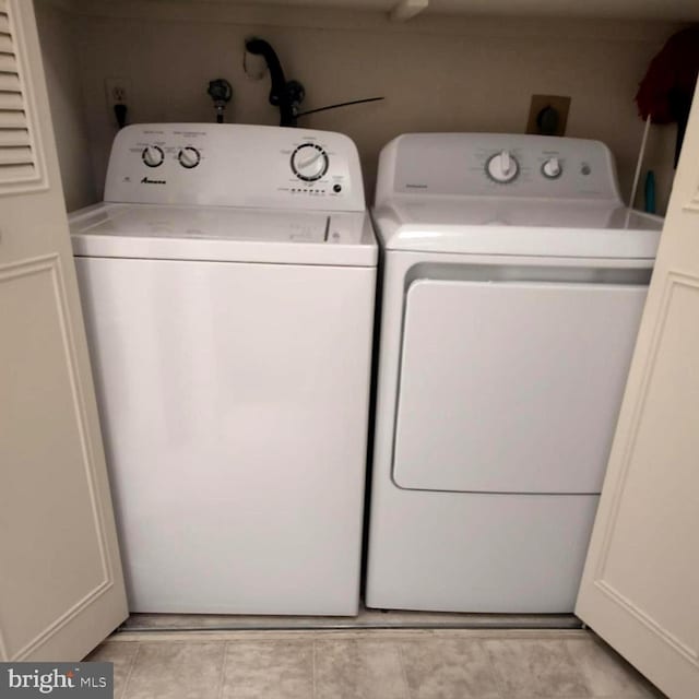 laundry area with laundry area, independent washer and dryer, and light tile patterned flooring