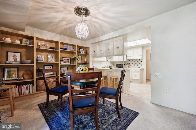 dining room with a chandelier and light carpet