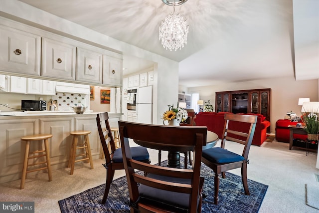 dining space featuring an inviting chandelier and light colored carpet