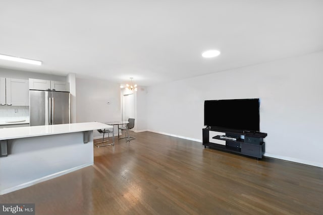 unfurnished living room with recessed lighting, baseboards, dark wood-style floors, and a chandelier