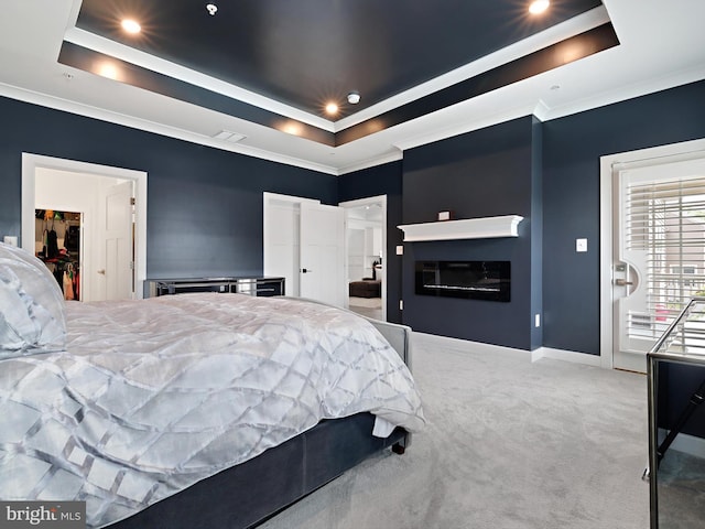 9929 Pesade Way, Upper Marlboro, MD 20772 - carpeted bedroom featuring a tray ceiling, a spacious closet, a glass covered fireplace, baseboards, and crown molding