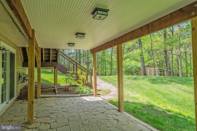 view of patio / terrace with a shed, an outbuilding, and stairway