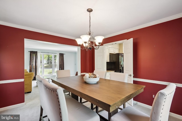 dining room featuring crown molding, baseboards, light carpet, and a notable chandelier