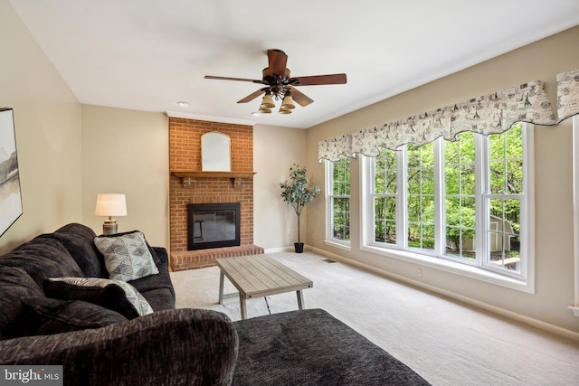 living area featuring carpet floors, visible vents, a brick fireplace, baseboards, and ceiling fan