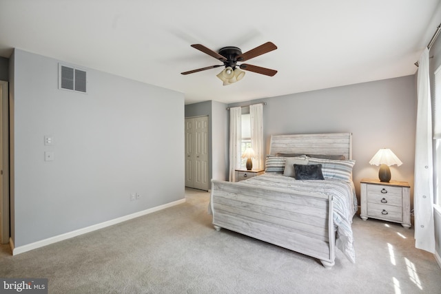 carpeted bedroom with baseboards, ceiling fan, a closet, and visible vents