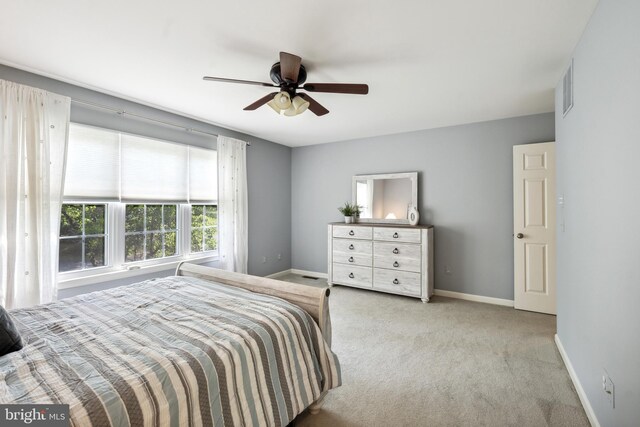 carpeted bedroom featuring a ceiling fan, baseboards, and visible vents