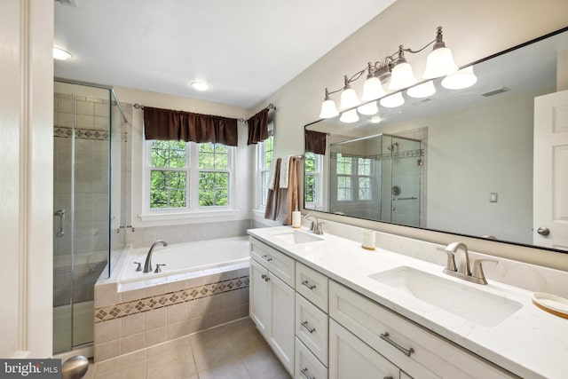 bathroom featuring double vanity, a bath, tile patterned floors, a sink, and a stall shower