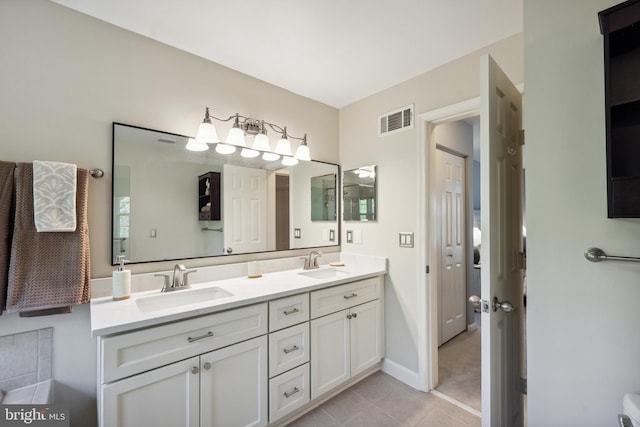 bathroom featuring double vanity, visible vents, a sink, and tile patterned flooring