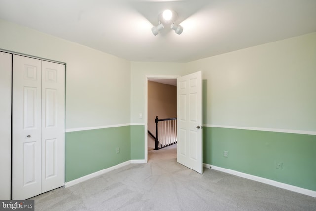 unfurnished bedroom featuring a closet, baseboards, and carpet flooring