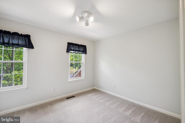 carpeted empty room with baseboards and visible vents