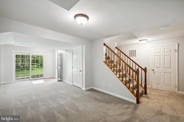 interior space featuring visible vents, carpet, baseboards, and stairway