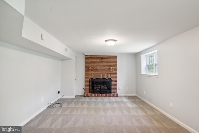 unfurnished living room with baseboards, a fireplace, and light carpet