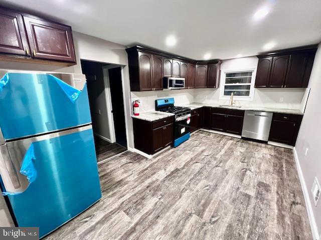 218 Cooper St, Beverly, NJ 08010 - kitchen with a sink, stainless steel appliances, light wood finished floors, and dark brown cabinets