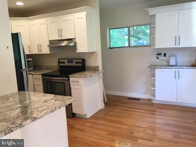 13211 Lutes Dr, Silver Spring, MD 20906 - kitchen featuring stainless steel electric range, open shelves, light wood finished floors, under cabinet range hood, and white cabinetry