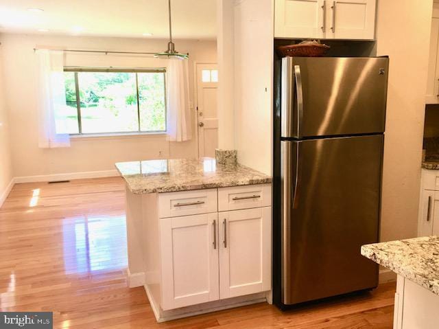 13211 Lutes Dr, Silver Spring, MD 20906 - kitchen with freestanding refrigerator, baseboards, light wood-style flooring, and white cabinetry