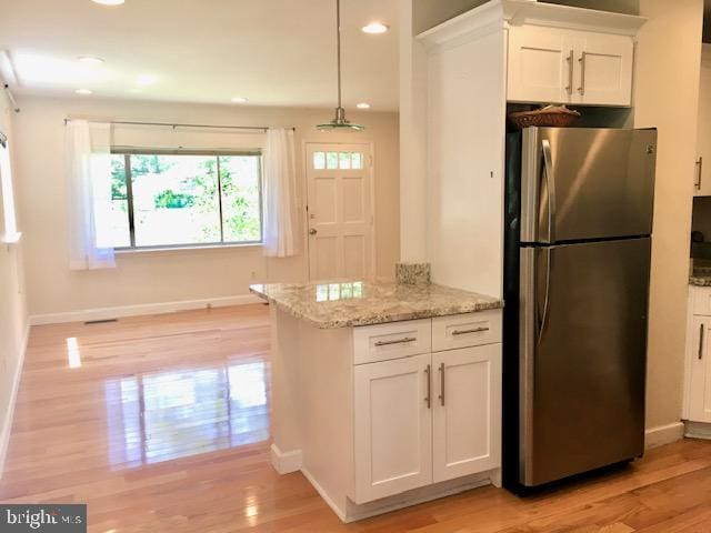13211 Lutes Dr, Silver Spring, MD 20906 - kitchen featuring freestanding refrigerator, white cabinets, light wood-style floors, light stone counters, and recessed lighting