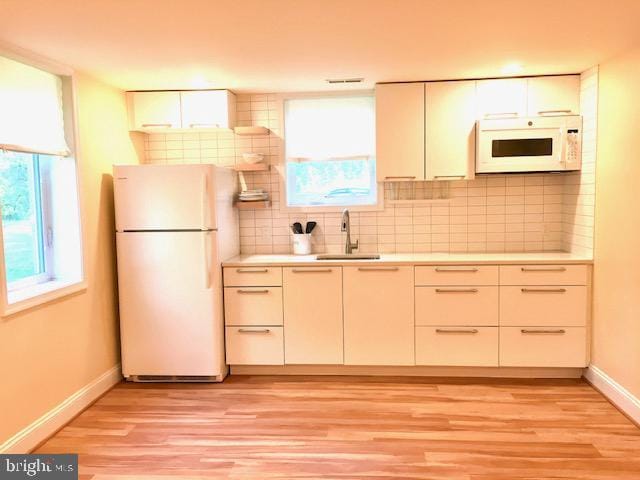 13211 Lutes Dr, Silver Spring, MD 20906 - kitchen featuring white appliances, a sink, light countertops, light wood-type flooring, and baseboards