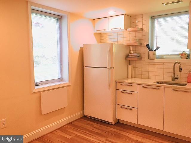 13211 Lutes Dr, Silver Spring, MD 20906 - kitchen featuring freestanding refrigerator, a sink, backsplash, light wood-type flooring, and light countertops