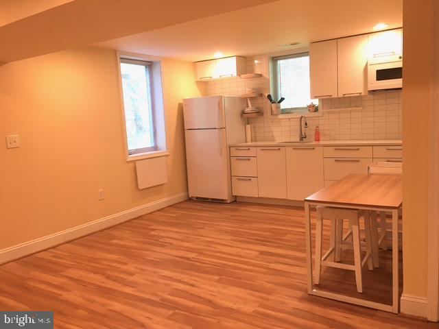 13211 Lutes Dr, Silver Spring, MD 20906 - kitchen with white appliances, baseboards, white cabinets, and light wood-style floors