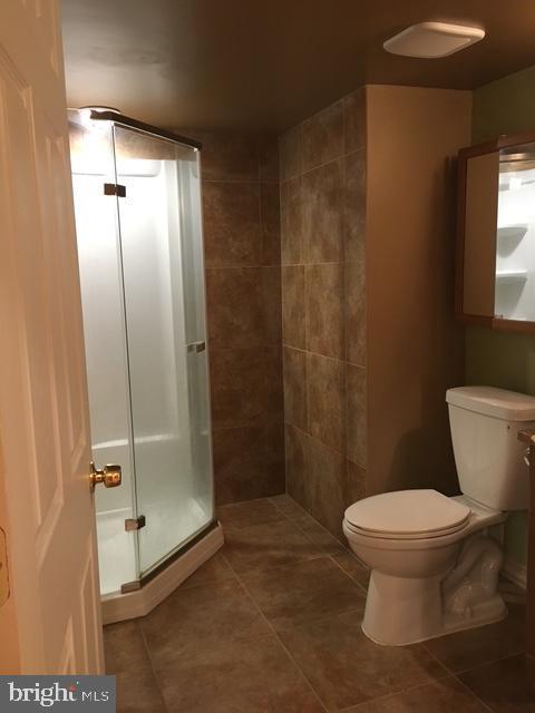 13211 Lutes Dr, Silver Spring, MD 20906 - bathroom featuring tile patterned flooring, a shower stall, and toilet
