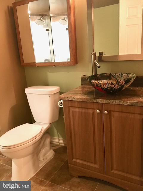 13211 Lutes Dr, Silver Spring, MD 20906 - half bath with toilet, vanity, tile patterned flooring, and baseboards