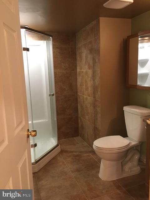 13211 Lutes Dr, Silver Spring, MD 20906 - full bath featuring a shower stall, toilet, and tile patterned flooring
