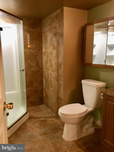 13211 Lutes Dr, Silver Spring, MD 20906 - full bathroom featuring a shower stall, vanity, toilet, and tile patterned floors