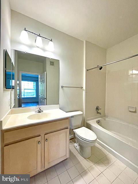 bathroom with tile patterned flooring, bathing tub / shower combination, toilet, and vanity
