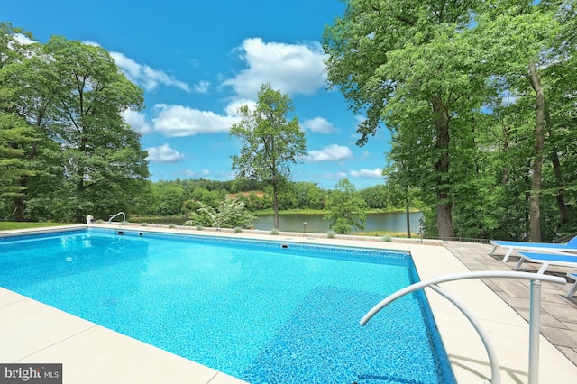 174 Springhouse Ln, Spring Grove, PA 17362 - outdoor pool with a patio, a water view, and view of wooded area