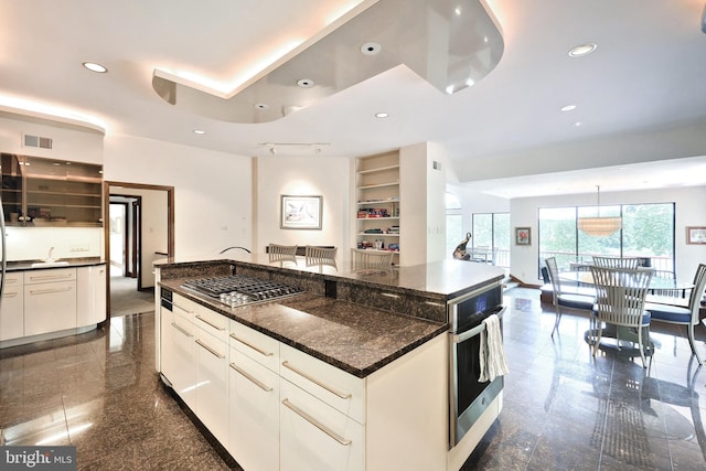 174 Springhouse Ln, Spring Grove, PA 17362 - kitchen featuring appliances with stainless steel finishes, a large island, white cabinetry, dark stone countertops, and recessed lighting