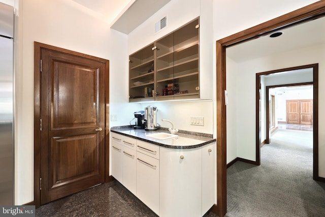 174 Springhouse Ln, Spring Grove, PA 17362 - kitchen with a sink, dark countertops, stainless steel fridge, white cabinets, and baseboards