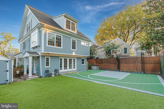 view of basketball court featuring fence, a storage shed, basketball court, a gate, and a yard
